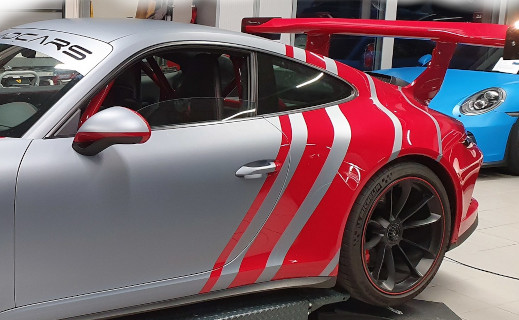 Covering partiel gris et rouge sur une voiture de sport